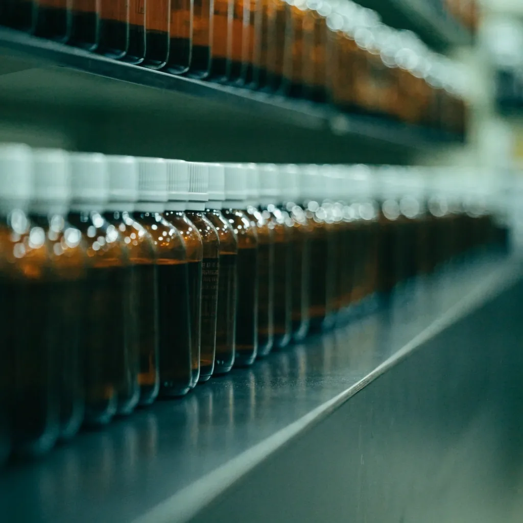 Amber-glass bottles with plain caps seen from an angle along a shelf